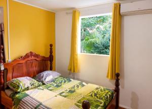 a bedroom with a bed and a window at Maison charmante à Pointe Noire, vue montagne, jardin privé in Pointe-Noire +22 photos