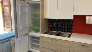 a kitchen with an empty refrigerator and a sink at Megaride's dépendance in Como
