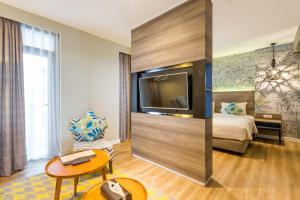 pokój hotelowy z łóżkiem i telewizorem w obiekcie Wyndham Garden Kuta Beach Bali w mieście Kuta