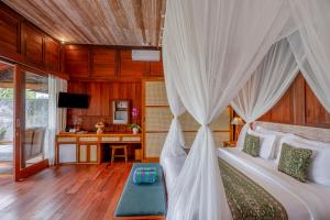 a bedroom with a bed with a canopy at Aranya Ubud Villa in Ubud