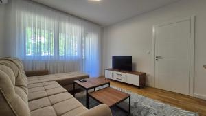 a living room with a couch and a television at MyPlace apartmani 8 in Tuzla