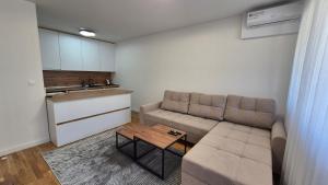 a living room with a couch and a table at MyPlace apartmani 8 in Tuzla