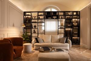 a living room with a couch and a shelf at Patria Palace Lecce - The Leading Hotels of The World in Lecce