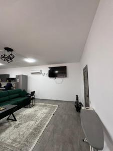 a living room with a green couch and a tv at Bon Hostel Kg in Bishkek
