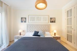 a bedroom with a large bed and two lamps at San Roque Golf Apartment in San Roque