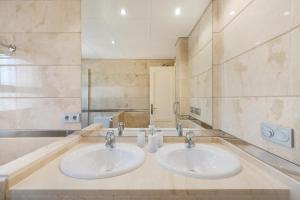 a bathroom with two sinks and a large mirror at San Roque Golf Apartment in San Roque +23 photos