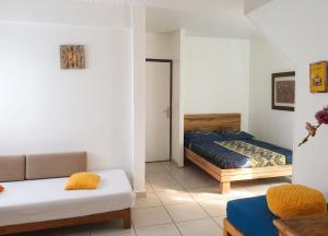 a living room with two beds and a couch at Studio charmant à La Trinité - Vue mer - 40 m² in La Trinité