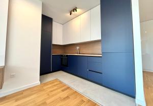 a kitchen with blue and white cabinets and wood floors at 1bd New and Modern Apt with Sea View "Blue Horizon" in Bar