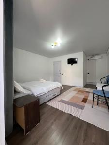 a bedroom with a bed and a table and a tv at Bon Hostel Kg in Bishkek