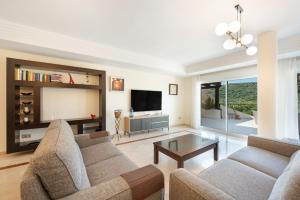 a living room with two couches and a flat screen tv at San Roque Golf Apartment in San Roque