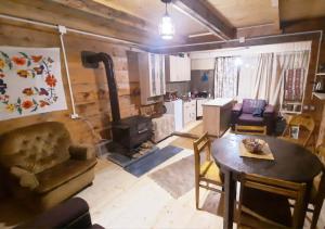 a living room with a table and a stove at Bakhmaro Lodge in Chʼkhakoura