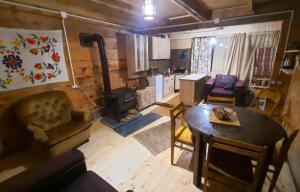 a living room with a table and a kitchen at Bakhmaro Lodge in Chʼkhakoura +45 photos