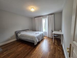 a bedroom with a bed and a desk and a window at Executive Room in North York Centre in Toronto
