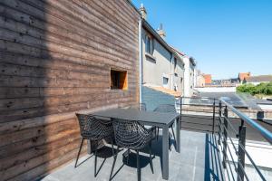 a patio with a table and chairs on a balcony at Beautiful and spacious renovated home for 10 in Ostend
