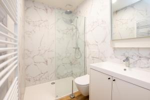 a white bathroom with a shower and a toilet at Beautiful and spacious renovated home for 10 in Ostend +20 photos