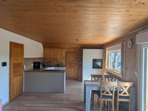 eine Küche mit Holzdecke, Tisch und Stühlen in der Unterkunft Gemütlich & einladend in Laufenselden