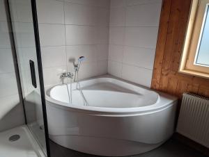 eine weiße Badewanne in einem Badezimmer mit Fenster in der Unterkunft Gemütlich & einladend in Laufenselden + 18 Fotos