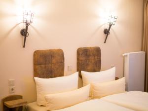 a bedroom with a bed with two lights on the wall at Hasseröder Burghotel in Wernigerode