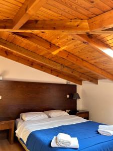 a bed in a room with a wooden ceiling at Aegean Sea Rooms in Chios