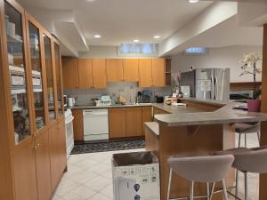 a large kitchen with wooden cabinets and a counter at Executive Room in North York Centre in Toronto +5 photos