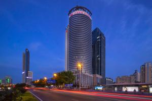a tall building with a sign on it in a city at Crowne Plaza Qingdao by IHG in Qingdao