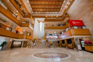 a large lobby with a staircase in a building at Crowne Plaza Qingdao by IHG in Qingdao +262 photos
