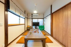 a room with a wooden table and a television at Kamenoya, 羽田空港&ディズニー直通バス,2トイレ,亀有駅徒歩7分 in Tokyo
