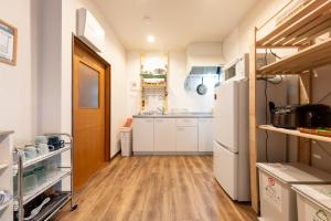 a kitchen with white appliances and a wooden floor at Kamenoya, 羽田空港&ディズニー直通バス,2トイレ,亀有駅徒歩7分 in Tokyo
