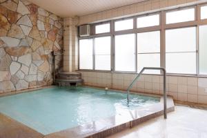 a pool of water in a room with windows at kkrshirahamamihamasou in Shirahama
