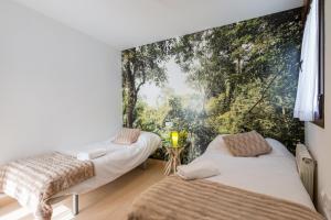 two beds in a room with a large window at Albaicin Luxury Apartments in Granada