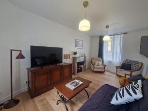 a living room with a couch and a tv at Gite De Sandra #Confort in Olby