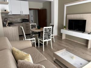a living room with a couch and a table with chairs at Корал, Хотел, Поморие in Pomorie +21 photos