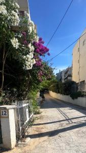 a street with flowers on the side of a building at Hera's apartment in Porto Rafti