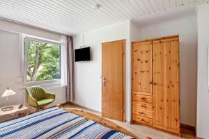 a bedroom with a bed and a wooden closet at Haus Hermes in Kirchhundem