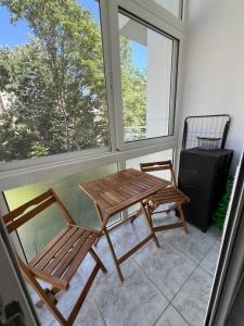 a table and two chairs in front of a window at Home Sweet Home AXD in Alexandroupoli