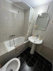 a bathroom with a toilet and a sink and a tub at Home Sweet Home AXD in Alexandroupoli +2 photos