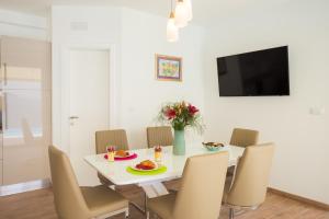 una sala da pranzo con tavolo e sedie bianchi di Hedera Estate, Villa Hedera VI a Dubrovnik