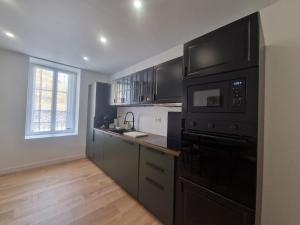 a kitchen with a black stove top oven next to a window at Gite De Sandra #Confort in Olby +2 photos