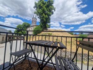 a table and two chairs on a balcony with a church at Gite De Sandra #Confort in Olby