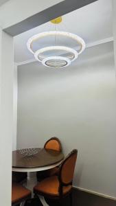 a dining room with a table and a chandelier at Hera's apartment in Porto Rafti