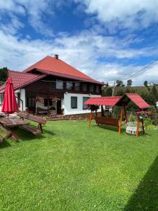 a house with a yard with picnic tables at Popas Turistic Gyl in Arieşeni