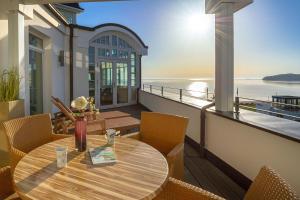 a table on a balcony with a view of the water at Strandschloss Binz - Penthouse "Royal Beach" mit Sauna, Kamin, Terrasse, Meerblick in Binz