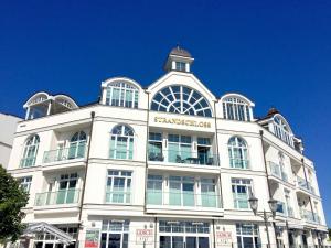 a white building with a clock tower on top of it at Strandschloss Binz - Penthouse "Royal Beach" mit Sauna, Kamin, Terrasse, Meerblick in Binz