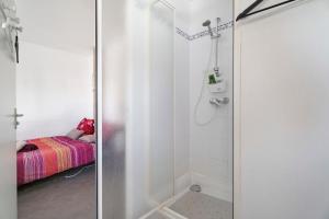 a bathroom with a shower and a bed in a room at Joli Duplex Centre-ville 5km Dinard in Pleurtuit +17 photos