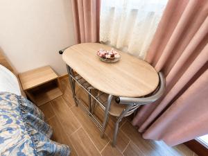 a table with a bowl of flowers on it in front of a window at Apartment Alee in Lesce +4 photos