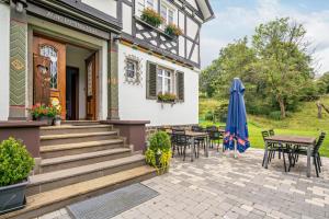 a patio with tables and chairs and an umbrella at Haus Hermes in Kirchhundem