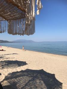 a person standing on a beach with the ocean at Aeria Elegant Luxury Villa in Asprovalta