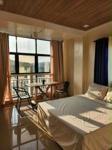 a bedroom with a bed and a table with chairs at R Hotel Centro and Restaurant in Marinduque