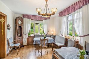 a living room with a table and chairs and a clock at Haus Hermes in Kirchhundem