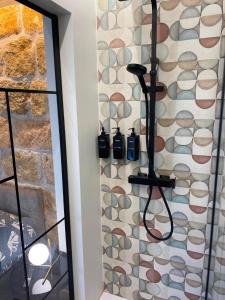 a shower in a bathroom with a stone wall at Cavour 106 Apartment in Palermo